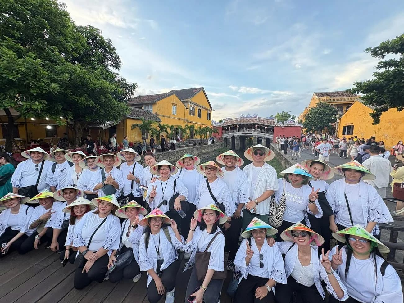 Travellers by the riverside in Hoi An wearing conical hats.