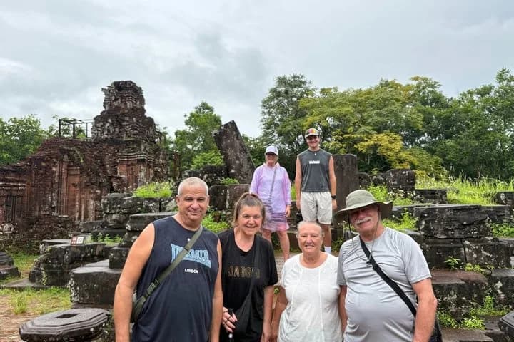 Selfie with Fin and two travellers smiling at the My Son brick temples on a sunny day.