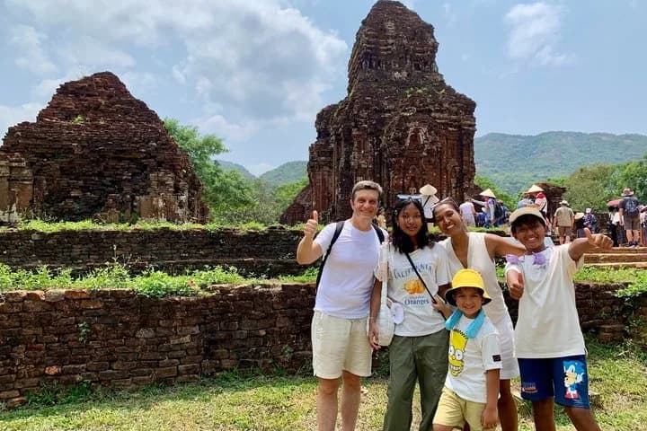 Travellers admiring the carved sandstone details of a Cham temple at My Son Sanctuary.