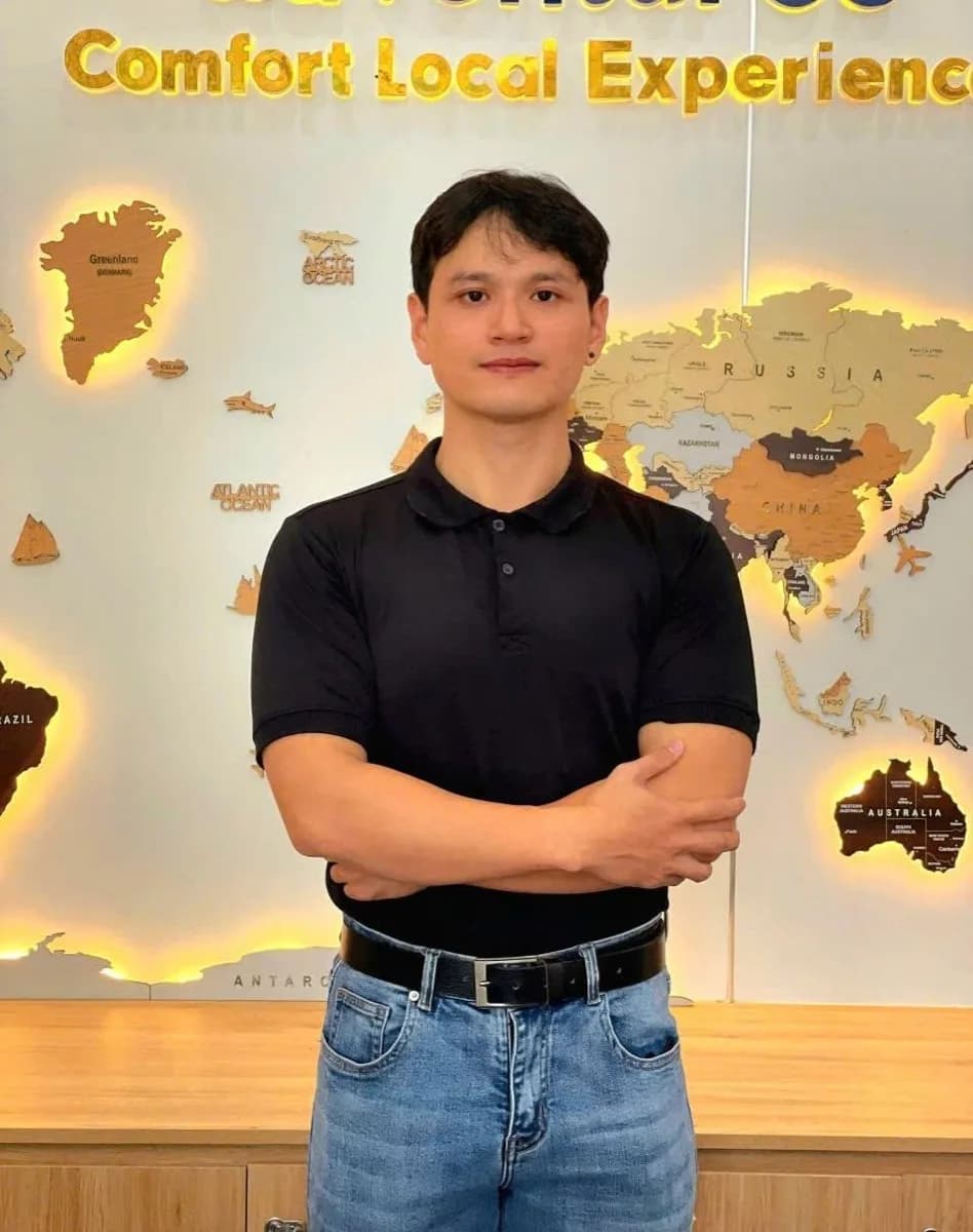 Fin (Fingo), local Hoi An private tour guide, standing confidently in front of a world map.