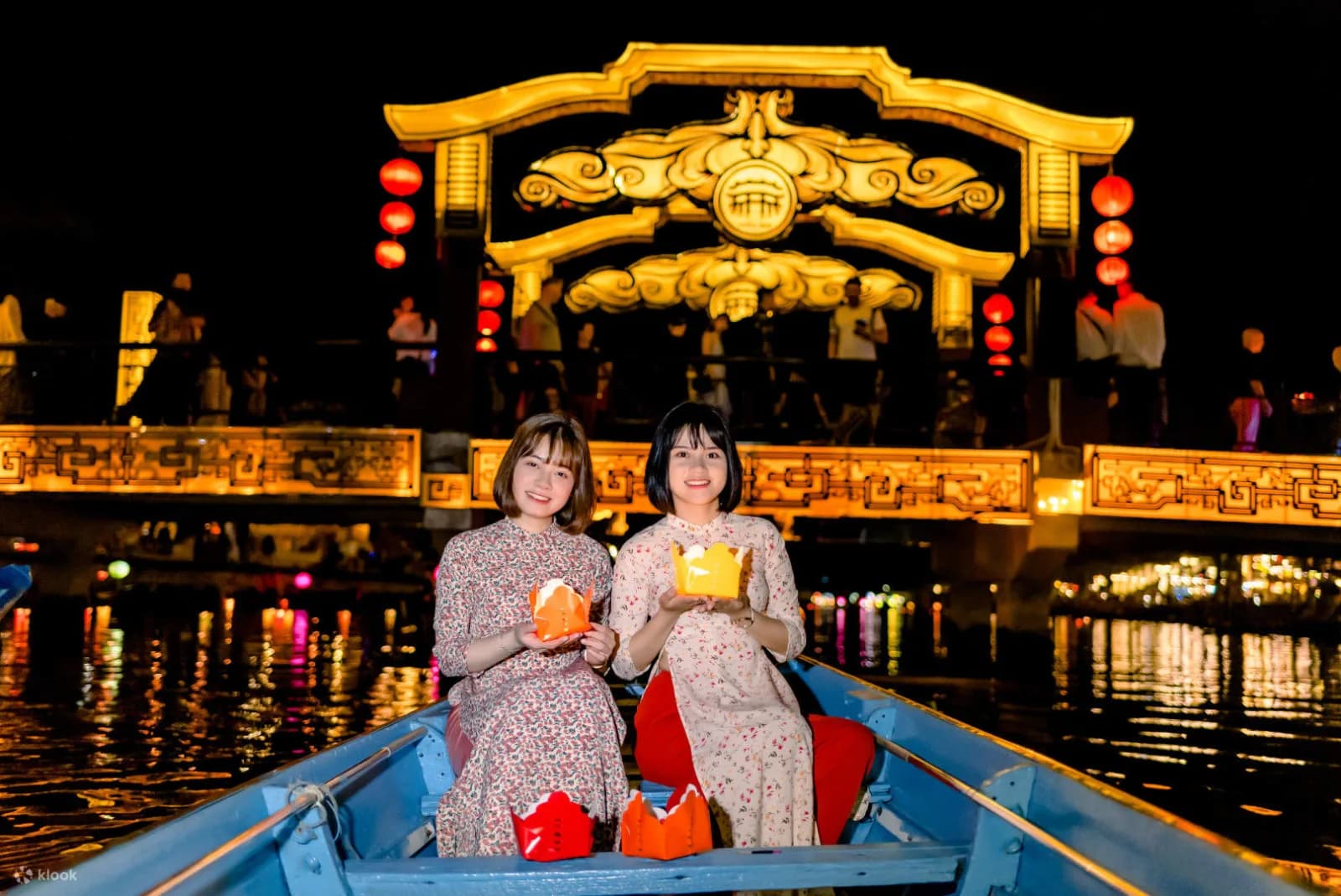 Guests releasing floating lotus lanterns on the Hoai River at night.