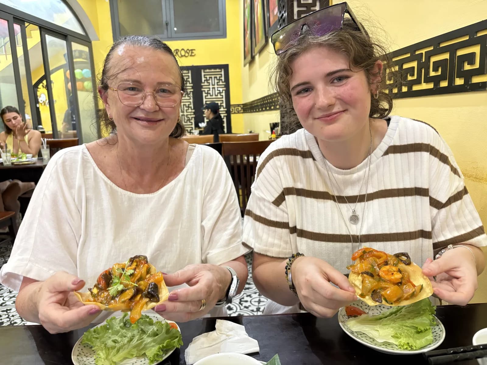 Guests tasting crispy fried wontons topped with sweet-and-sour seafood sauce, a Hoi An speciality.