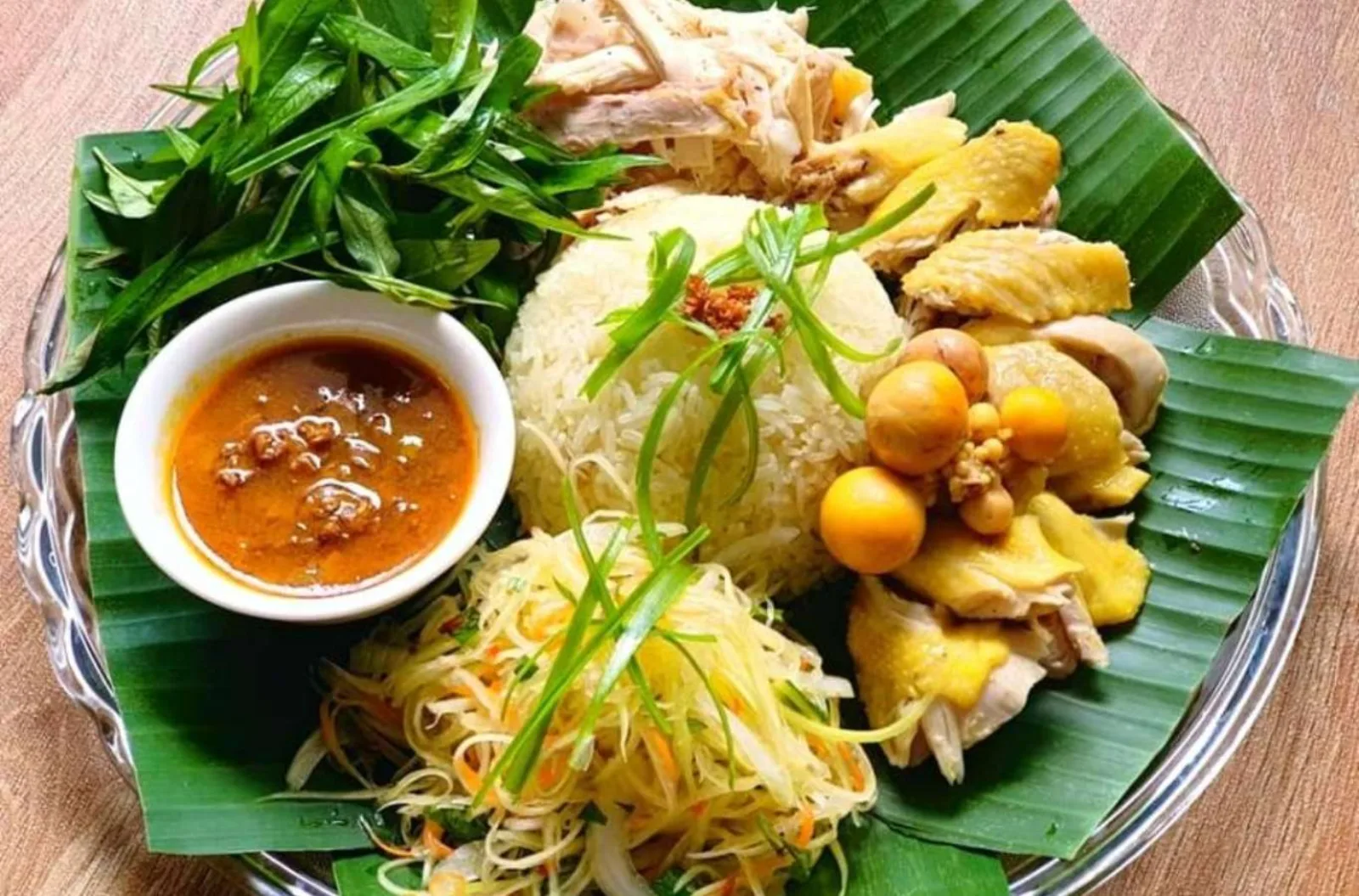 Com ga Hoi An — shredded chicken over turmeric rice with herbs and a bowl of broth.
