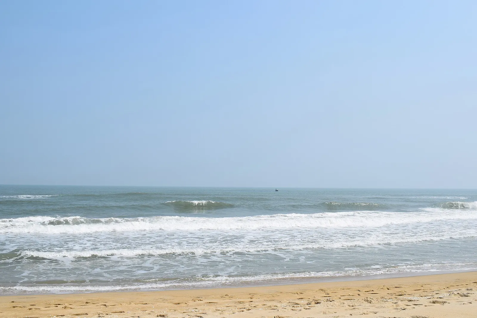 An Bang beach on a clear morning, with small waves rolling onto pale sand.