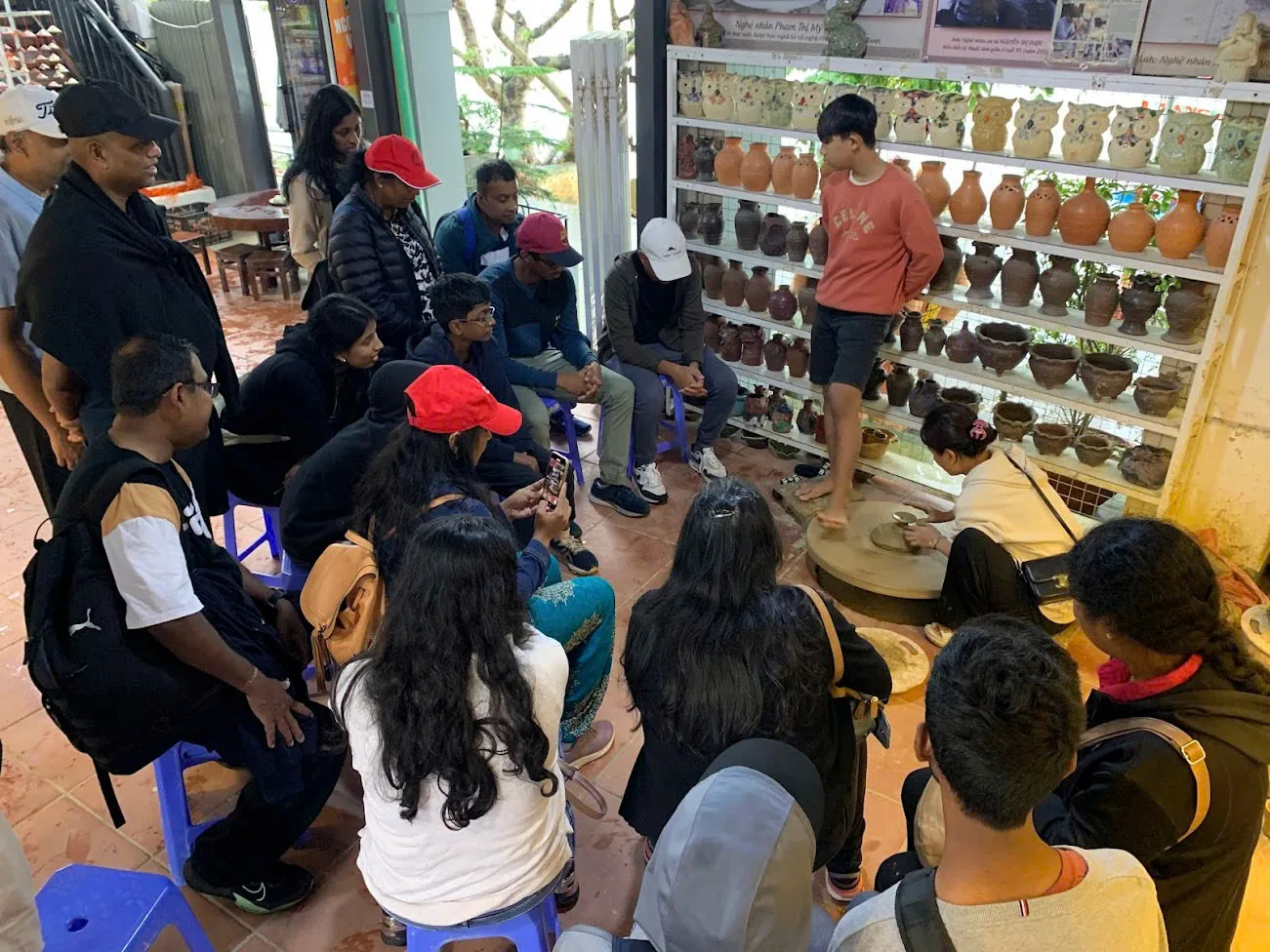 Guests at the kick wheel in a Thanh Ha pottery workshop, shaping river clay by hand.
