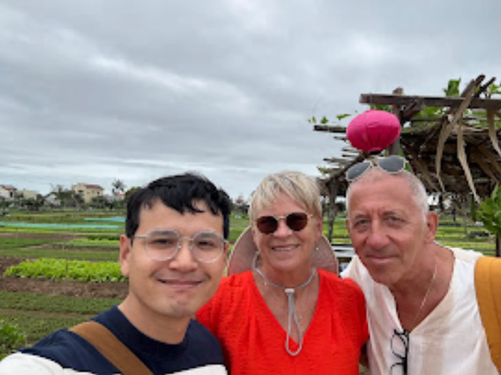Fin with guests at Tra Que herb village, framed by the vegetable gardens.