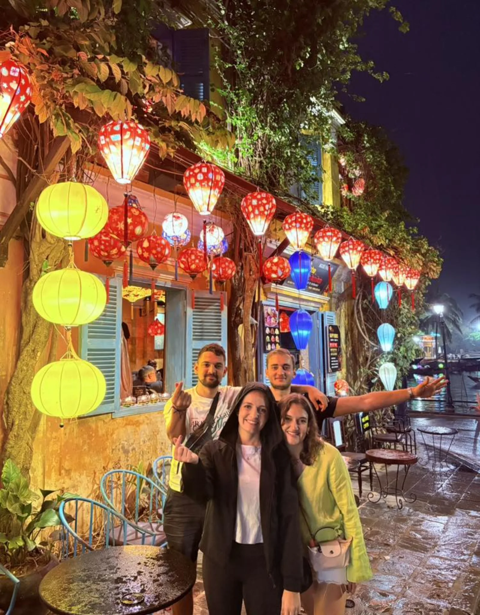 A private tour group in front of a lantern-lit cafe on an Old Town street at night.