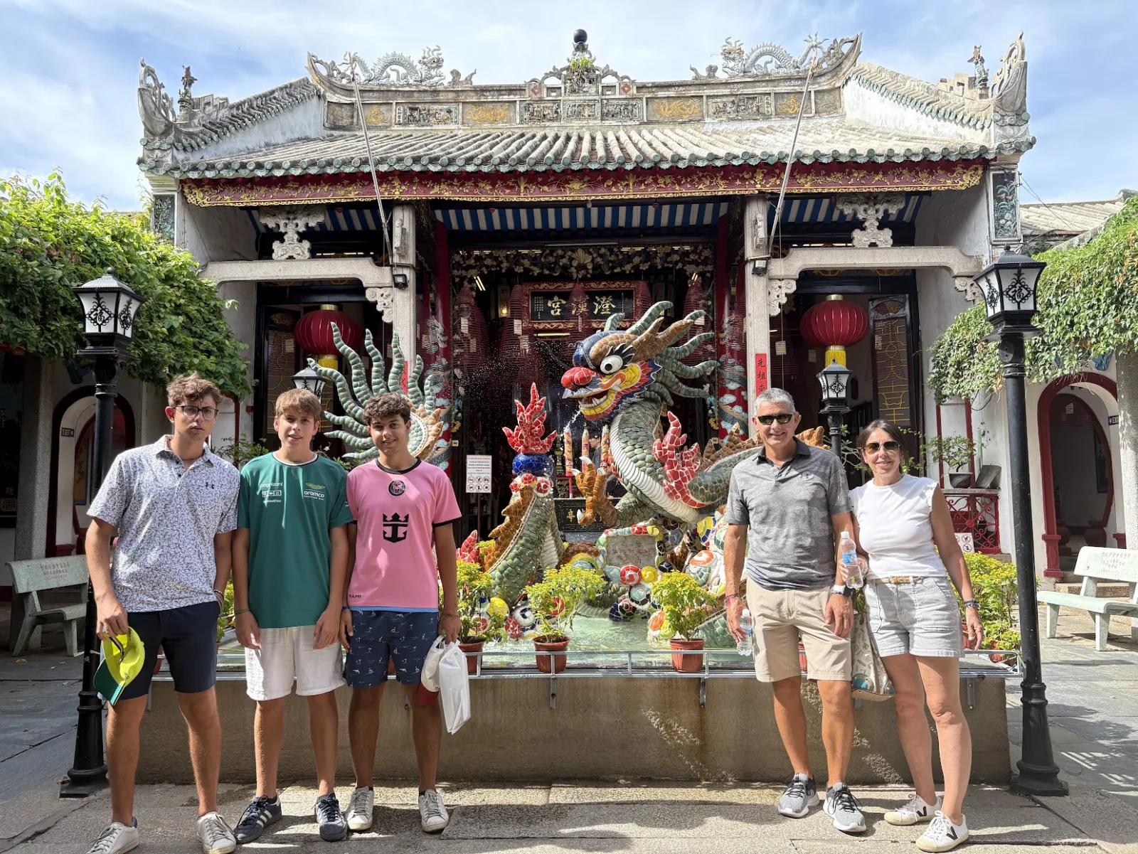 Five guests in the dragon-statue courtyard of Fujian Assembly Hall in Hoi An.
