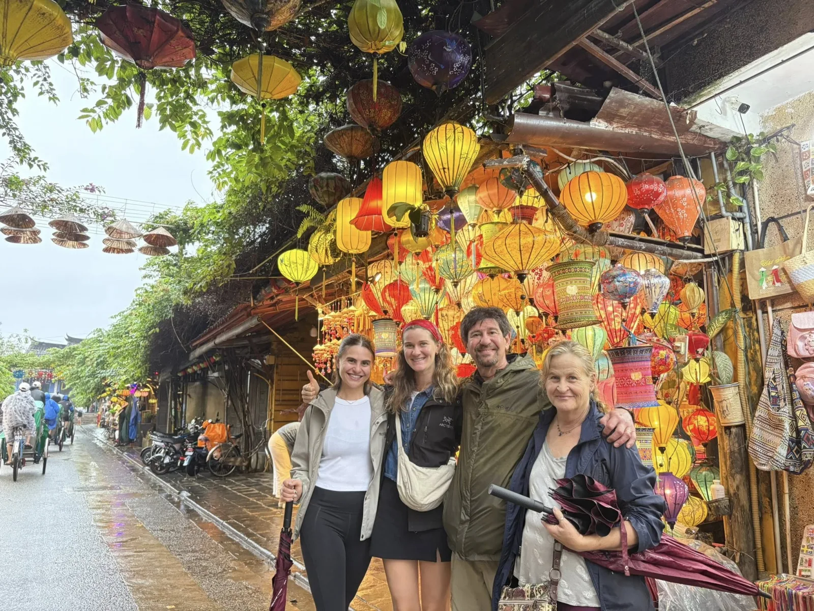 Four guests at a colourful lantern shop along a Hoi An Old Town street.